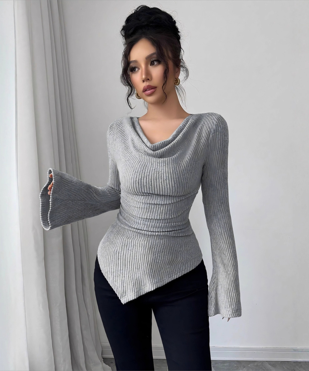 Woman wearing a gray ribbed sweater with a white background